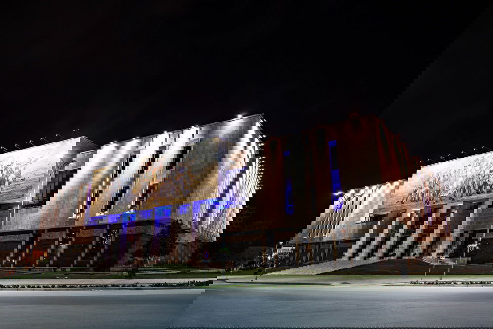 A large building at night in Tirana, offering an array of things to do.