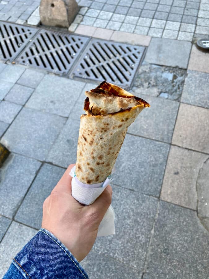 Mate enjoying istanbul street food on the sidewalk - Traditional Turkish Street Food Lahmacun